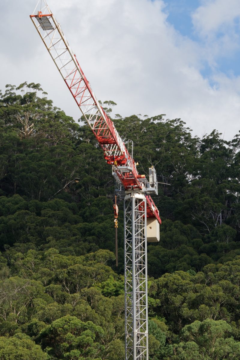Construction crane close up with bushland backdrop
